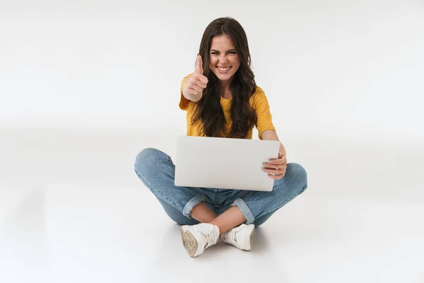 Emocional feliz alegre joven aislada sobre fondo blanco de la pared usando ordenador portátil hacer pulgares gesto hacia arriba . —  Fotos de Stock