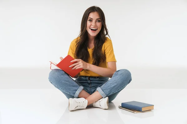 Positieve jonge vrouw geïsoleerd over witte muur achtergrond met notebook. — Stockfoto