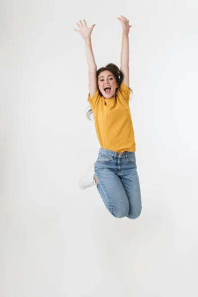 Feliz joven mujer emocional saltando aislado sobre fondo blanco de la pared con las manos levantadas . —  Fotos de Stock