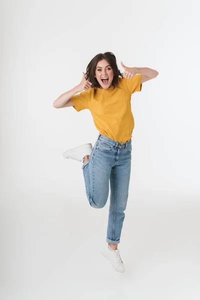 Sorprendido excitado joven mujer emocional saltando aislado sobre fondo blanco de la pared . — Foto de Stock