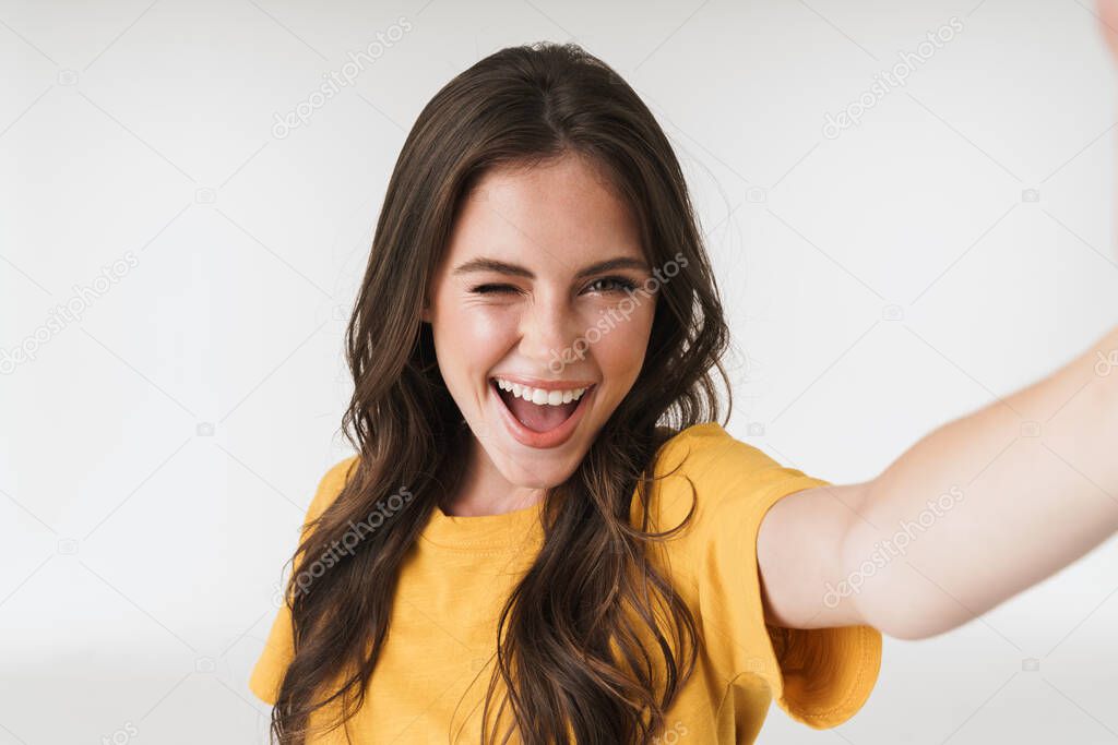 Image of happy brunette woman wearing casual t-shirt smiling and