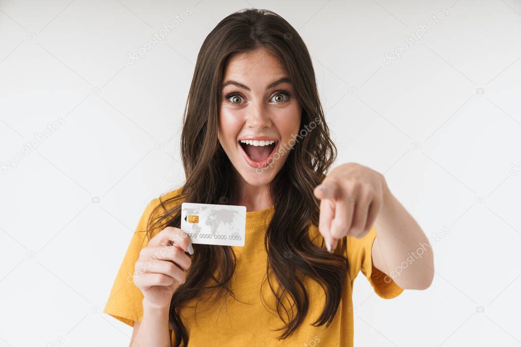 Image of pleased brunette woman wearing casual clothes pointing 