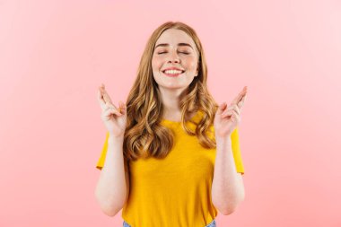 Pleased optimistic cute girl isolated over pink wall background showing hopeful please gesture.