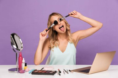 Makyaj fırçaları tutan yalnız poz veren kadın..