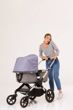 Bebek arabasıyla duran güzel, genç bir kadın.