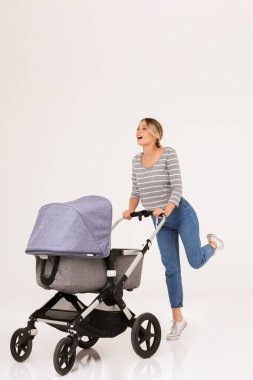 Bebek arabasıyla duran güzel, genç bir kadın.