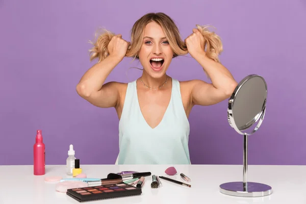 Obrázek vzrušené pěkné ženy drží její vlasy a dělá make-up — Stock fotografie