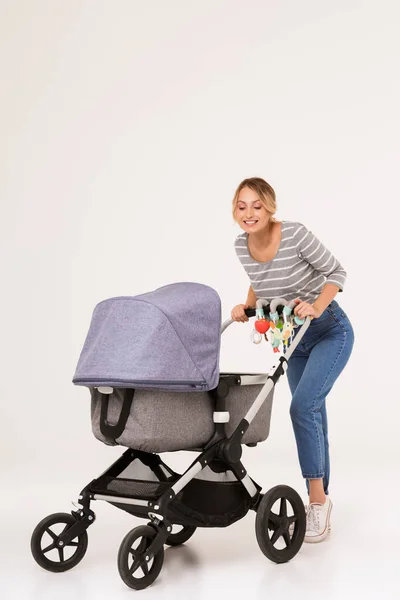 Blonde woman mother walking with baby in pram — Stock Photo, Image