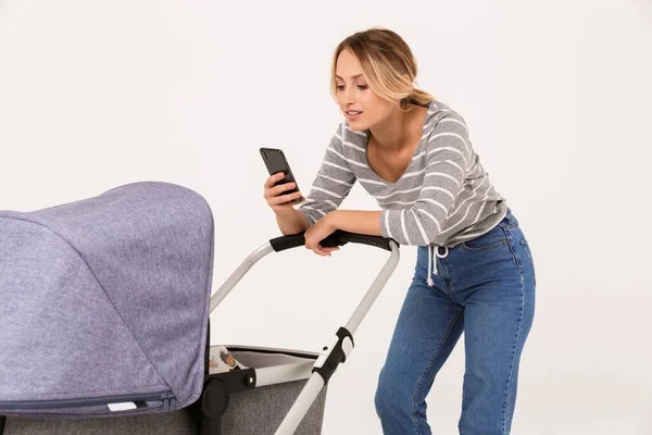 Beauituful young woman standing with a baby pram — Stock Photo, Image