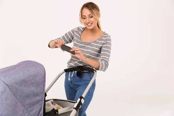 Image of smiling nice woman taking photo her baby in stroller — Stock Photo, Image