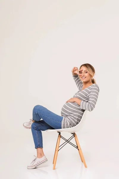 Çekici genç hamile kadın sandalyede oturuyor. — Stok fotoğraf