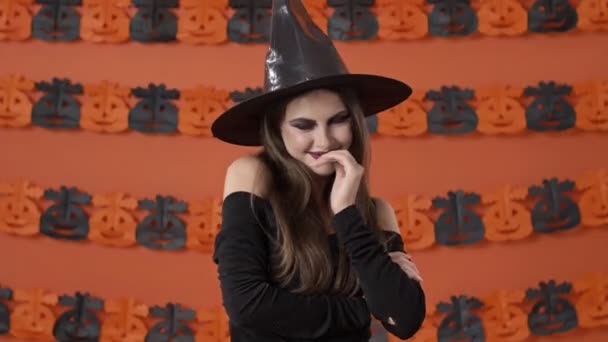 Flirty Tímida Jovem Bruxa Traje Preto Halloween Sorrindo Cobrindo Sua — Vídeo de Stock