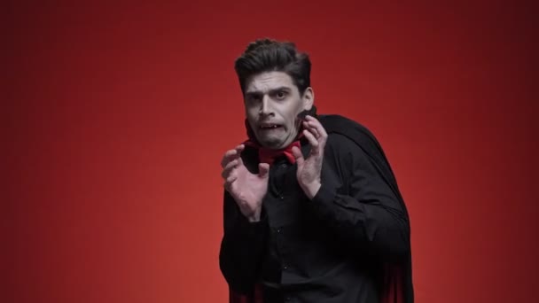 Siyah Cadılar Bayramı Kostümü Giymiş Vampir Adam Kırmızı Duvarın Üzerinden — Stok video