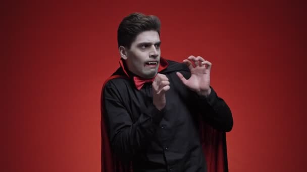 Недовольный Вампир Клыками Чёрном Костюме Хэллоуин Боится Глядя Изолированную Красную — стоковое видео