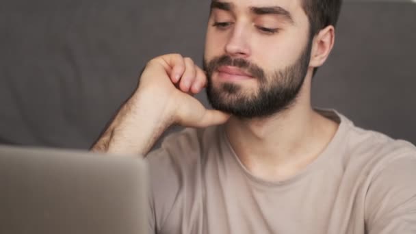 Een Kalme Jongeman Gebruikt Zijn Laptop Terwijl Hij Thuis Bank — Stockvideo