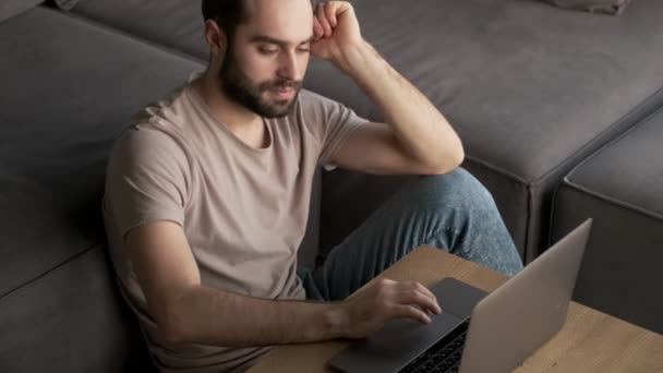 Stylový Pozitivní Mladý Muž Používá Svůj Notebook Zatímco Sedí Doma — Stock video