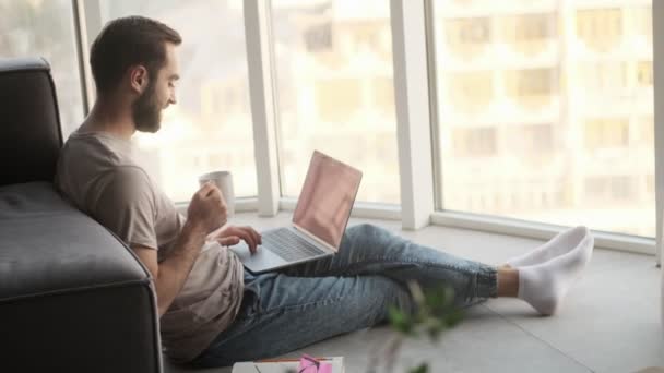 Boční Pohled Pohledného Mladého Muže Používá Svůj Notebook Zatímco Sedí — Stock video