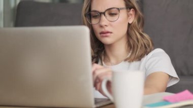 Evde dizüstü bilgisayar kullanan inanılmaz ciddi bir kadın.