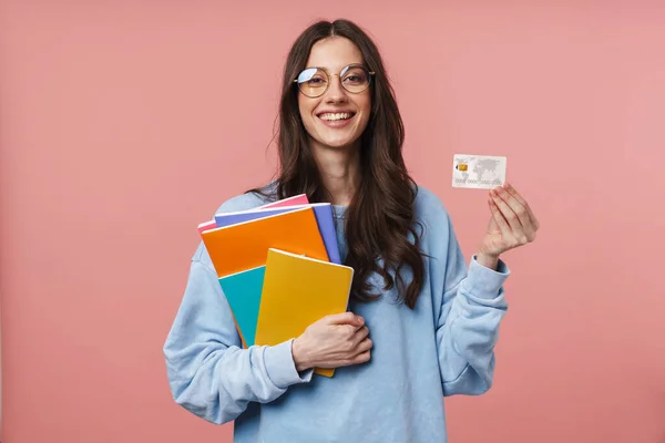 Beeld Van Lachende Jonge Vrouw Met Oefenboeken Creditcard Geïsoleerd Roze — Stockfoto