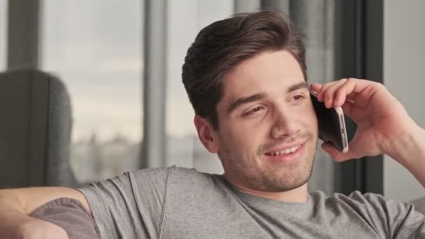 Fiatal Jóképű Elégedett Férfi Beszél Mobiltelefonnal Otthon — Stock videók