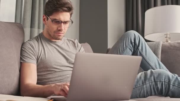 Jovem Homem Sério Casa Usando Computador Portátil — Vídeo de Stock
