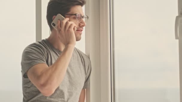 Evde Konsantre Olmuş Genç Bir Adam Cep Telefonuyla Konuşuyor — Stok video