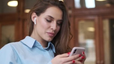 Kafede cep telefonu kullanan inanılmaz mutlu bir iş kadını.
