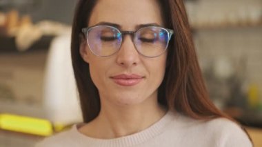 Kapalı bir kafede gülümseyen mutlu genç bir kadının yakın plan görüntüsü.