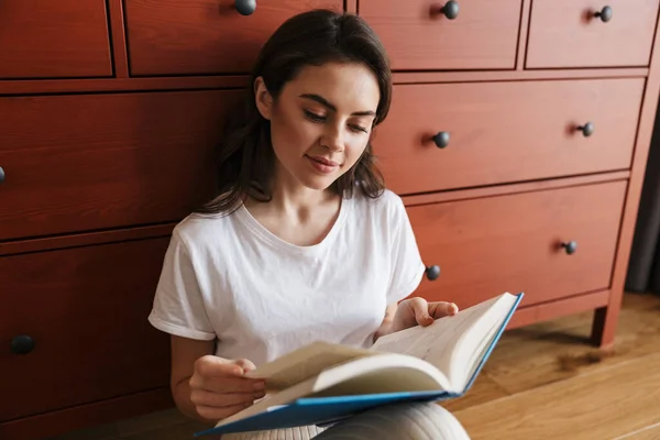 Attraente Giovane Donna Bruna Sorridente Che Legge Libro Mentre Siede — Foto Stock