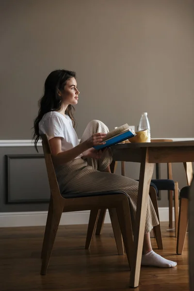 Atractiva Joven Morena Tomando Desayuno Saludable Leyendo Libro Mientras Está — Foto de Stock