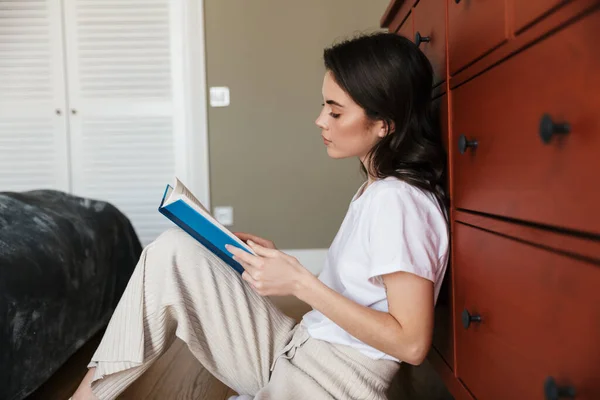 Attraente Giovane Donna Bruna Che Legge Libro Mentre Siede Pavimento — Foto Stock