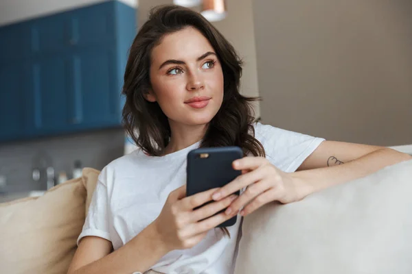 Mooie Glimlachende Jonge Brunette Vrouw Ontspannen Een Bank Thuis Met — Stockfoto