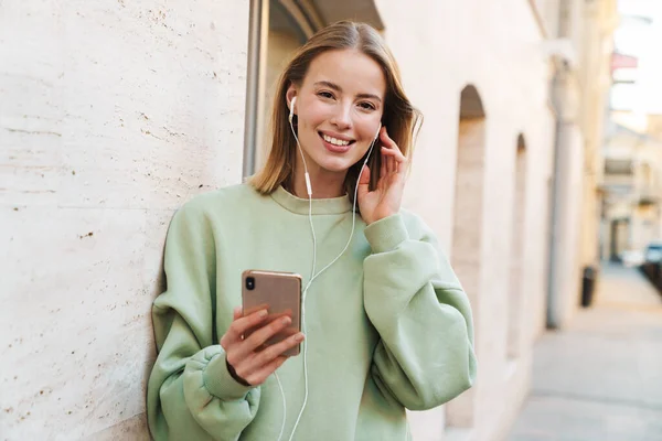 Porträt Einer Lächelnden Jungen Frau Die Kopfhörer Und Handy Benutzt — Stockfoto