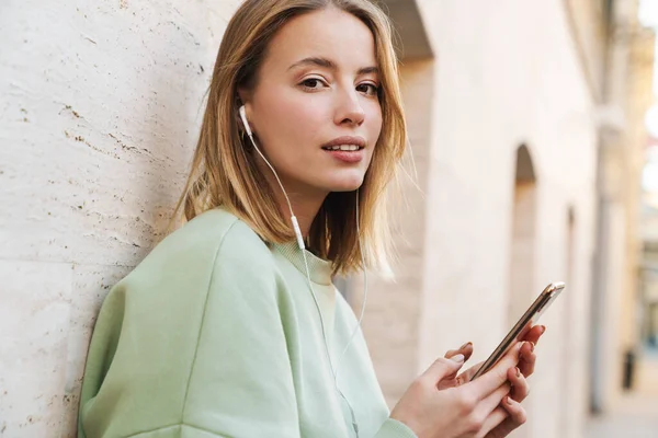 Retrato Una Hermosa Mujer Joven Usando Auriculares Teléfono Móvil Mientras — Foto de Stock