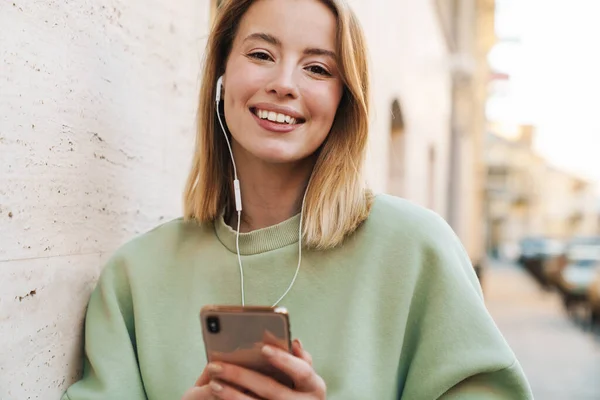 Porträt Einer Lächelnden Jungen Frau Die Kopfhörer Und Handy Benutzt — Stockfoto