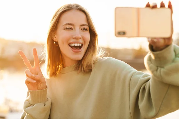 Portret Wesołej Kobiety Gestykulującej Znak Pokoju Robiącej Selfie Komórce Spacerując — Zdjęcie stockowe