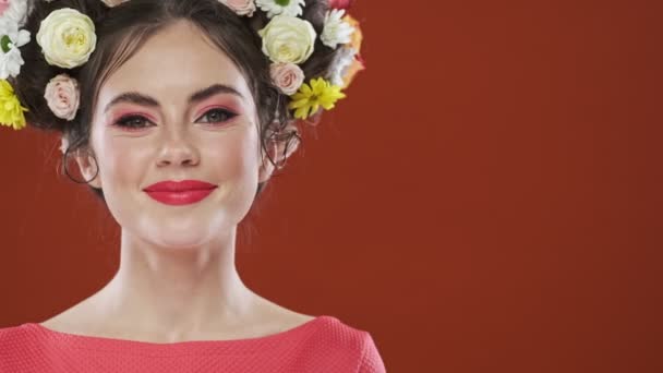 Μια Ελκυστική Χαμογελαστή Μελαχρινή Γυναίκα Ένα Καταπληκτικό Floral Χτένισμα Κοιτάζει — Αρχείο Βίντεο