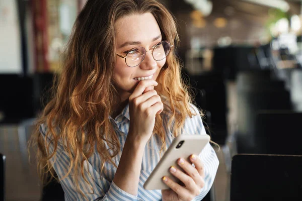 Beeld Van Vrolijke Jonge Vrouw Die Glimlacht Typt Mobiele Telefoon — Stockfoto