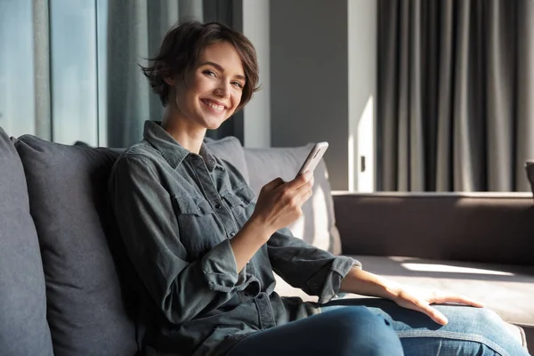 Bild Der Schönen Jungen Fröhlichen Frau Mit Handy Und Lächelt — Stockfoto