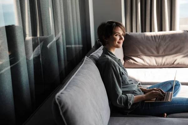 Bild Der Brünetten Netten Frau Mit Laptop Zufrieden Und Lächelnd — Stockfoto