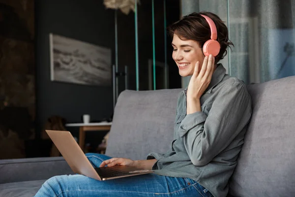 Image Nice Young Smiling Woman Using Laptop Headphones While Sitting — Stock Photo, Image