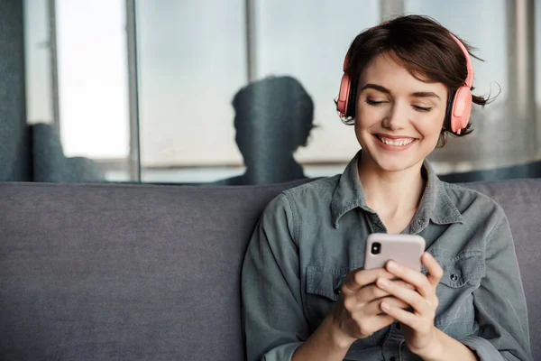 Image Nice Young Smiling Woman Using Smartphone Headphones While Sitting — Stock Photo, Image