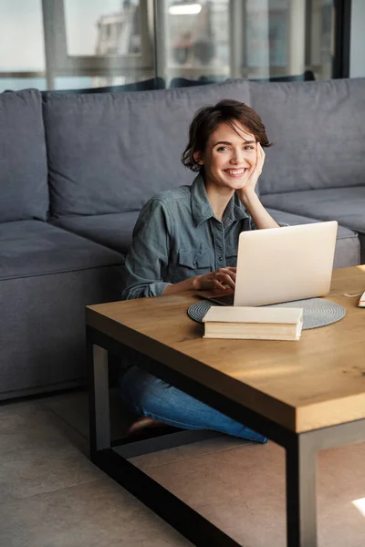 Imagem Jovem Mulher Alegre Agradável Usando Laptop Sorrindo Enquanto Sentado — Fotografia de Stock