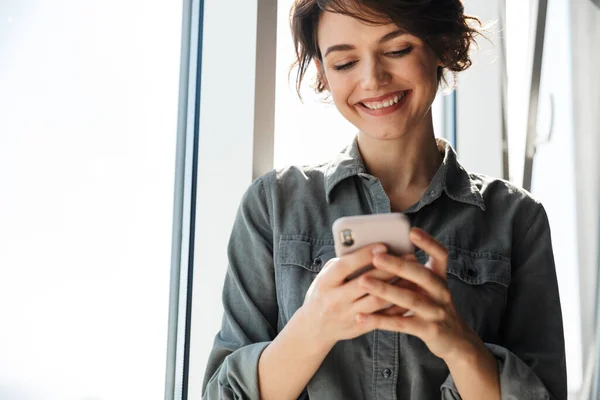 Зображення Красивої Молодої Радісної Жінки Використанням Мобільного Телефону Посмішкою Стоячи — стокове фото