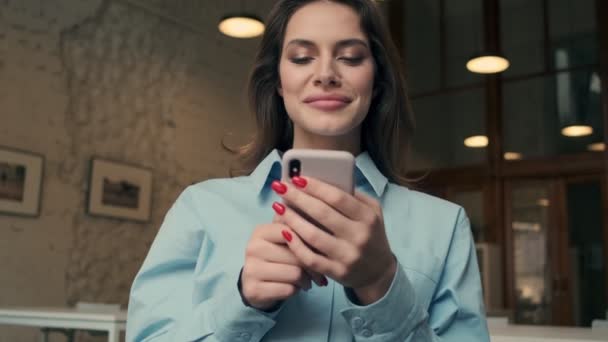 令人惊讶的年轻女商人在室内用手机喝咖啡 — 图库视频影像