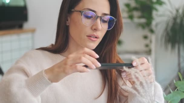 Gözlük Takan Güzel Bir Kadın Kapalı Bir Kafede Otururken Akıllı — Stok video
