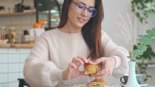 Vacker Kvinna Äter Croissant Sittandes Det Vita Mysiga Caféet — Stockvideo