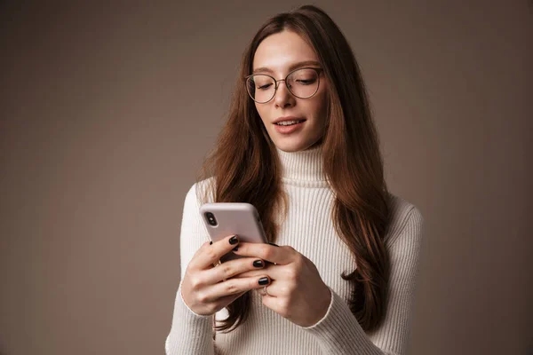 Foto Mulher Bonita Agradada Óculos Digitando Celular Isolado Sobre Parede — Fotografia de Stock