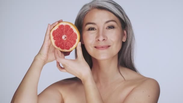 Гарна Стара Зріла Напівгола Жінка Довгим Сірим Волоссям Позує Грейпфрутом — стокове відео