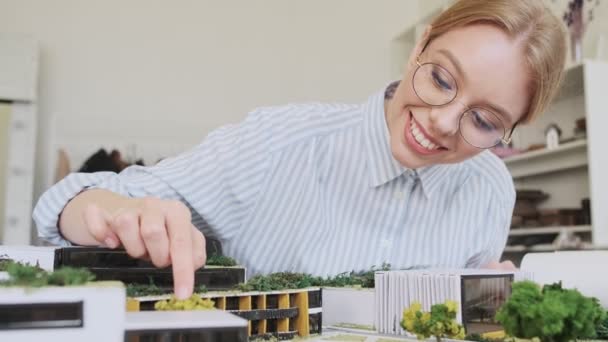 Приваблива Молода Блондинка Архітекторка Окулярах Проектує Модель Будинку Сидячи Сучасному — стокове відео